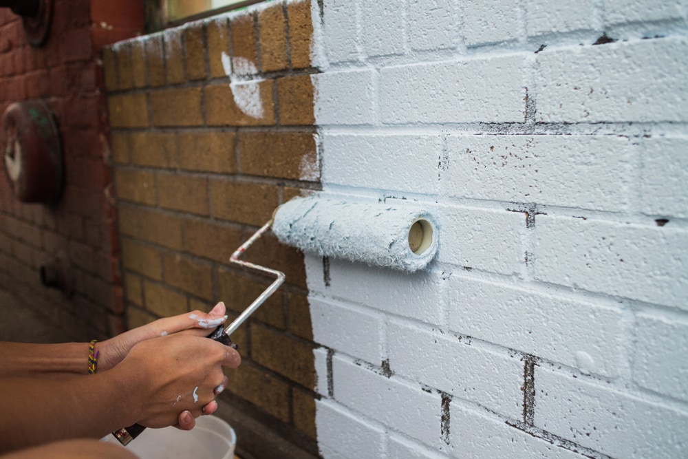 Person Painting Brick Wall